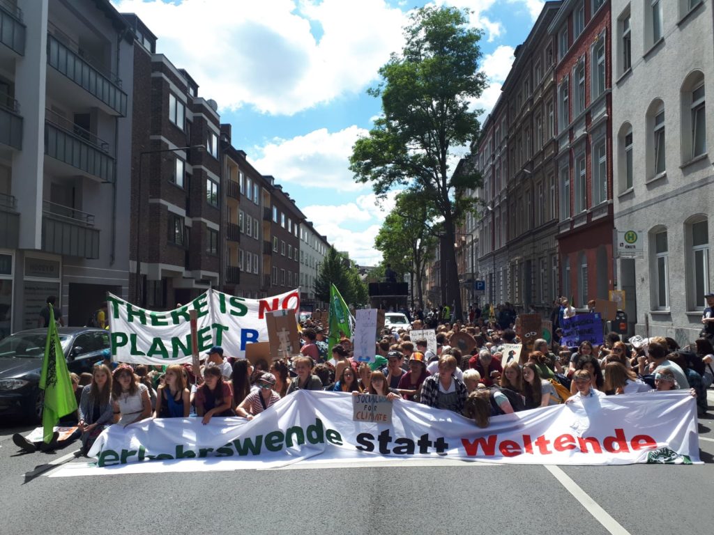 Banner "Verkehrsende statt Weltende", Sitzende Demonstranten